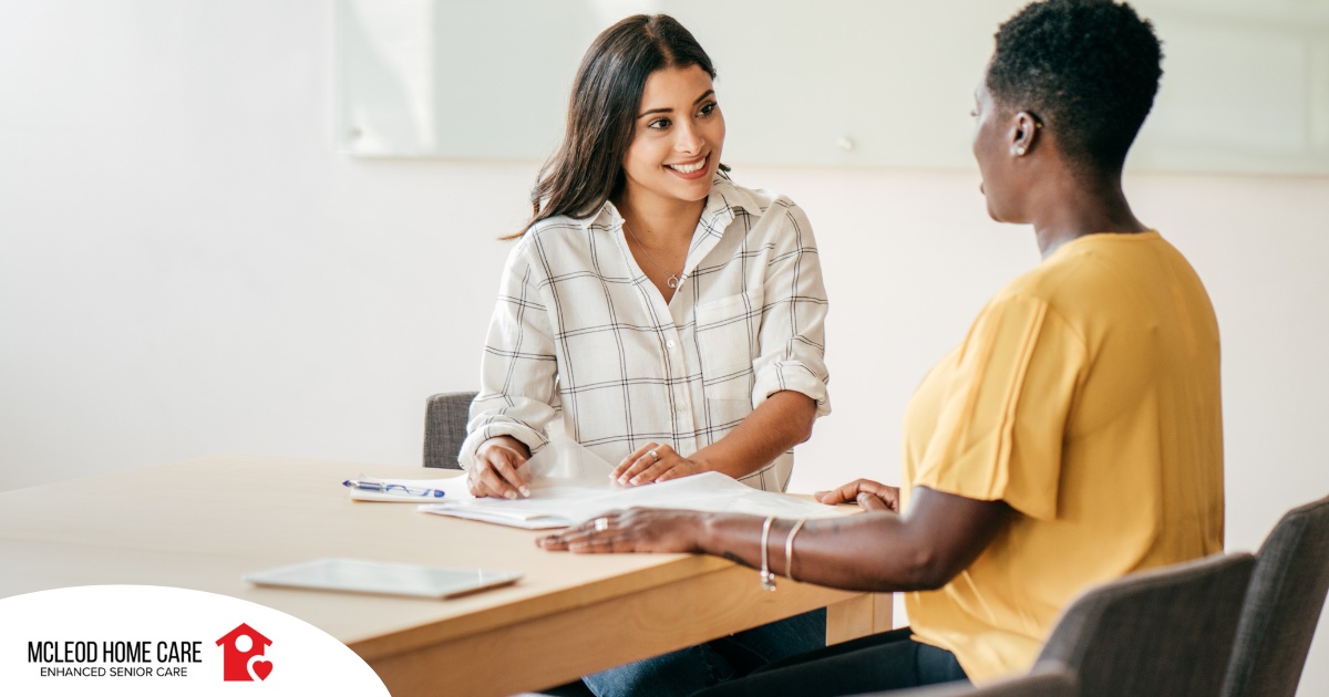 A woman happily interviews another woman, representing how well caregiver interviews can go when prepared.