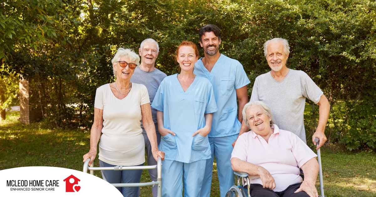2 caregivers and seniors smile while in a group representing how caregivers can facilitate socialization.