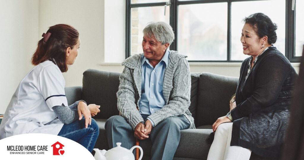 A caregiver talks with an elderly couple representing the kind of communication that professional caregivers need to have to anticipate client needs.
