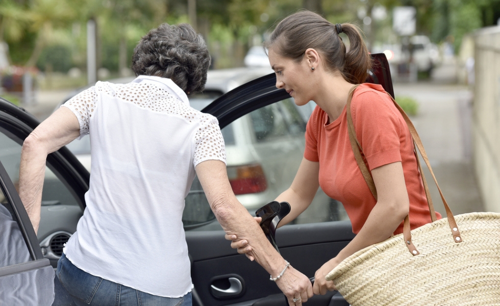 Transportation (1) A caregiver is assisting an elderly woman into a car, providing transportation services in Columbia to help ensure safe and comfortable travel.