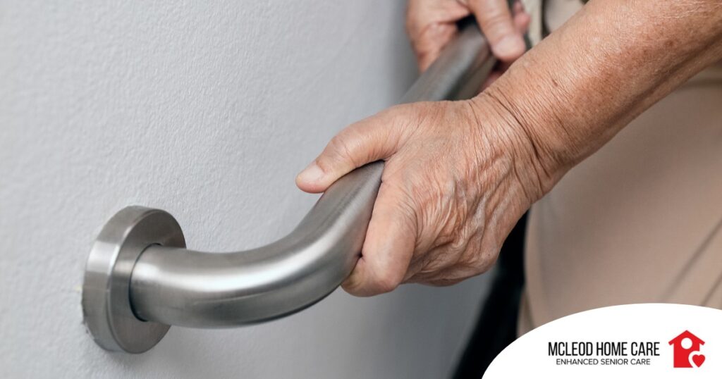 An older adult uses a grab bar representing one of the home modifications that is helpful for fall prevention for elderly adults.