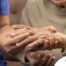 A care provider examines an older adult’s fingers, representing what would happen in an examination for rheumatoid arthritis.