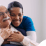 a graphic showing What a Week of Elder Care at Home Really Looks Like with a smiling caregiver and client