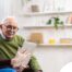 Home caregiver assisting senior man to use telehealth and senior care