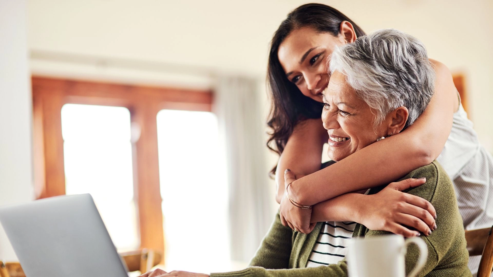 Caregiver hugging senior while using laptop – Tech Savvy Senior in Greenville, SC Caregiver hugging senior while using laptop - Tech Savvy Senior in Greenville, SC